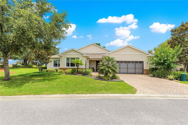 9925 SW 95th Loop, Ocala, FL 34481 - single story home with decorative driveway, an attached garage, a front lawn, and stucco siding