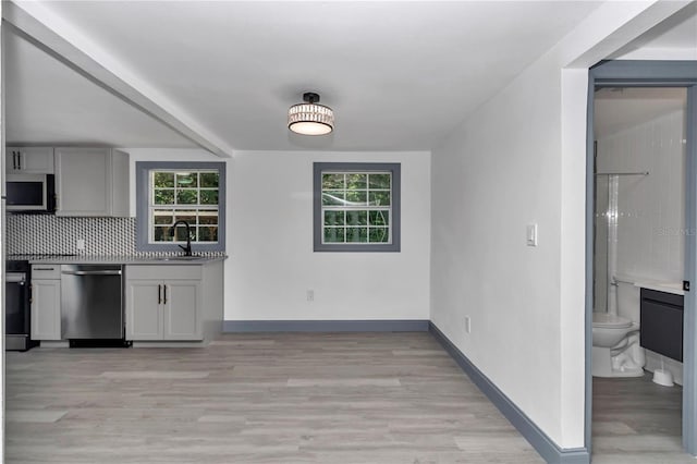 1636 SW 5th Pl, Ocala, FL 34471 - kitchen with appliances with stainless steel finishes, gray cabinets, light wood-style floors, and healthy amount of natural light