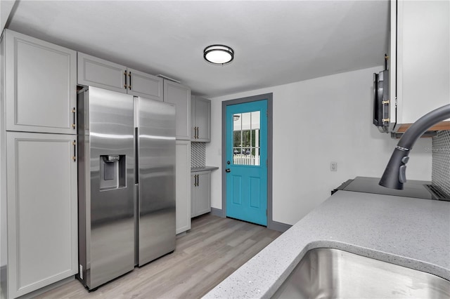 1636 SW 5th Pl, Ocala, FL 34471 - kitchen with stainless steel fridge, light wood-type flooring, light stone countertops, and gray cabinets