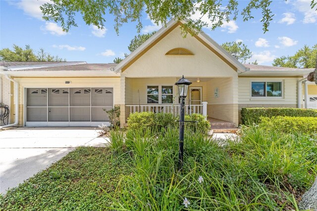 9085 SW 96th Ln Unit B, Ocala, FL 34481 - view of front of house with an attached garage, driveway, covered porch, and brick siding