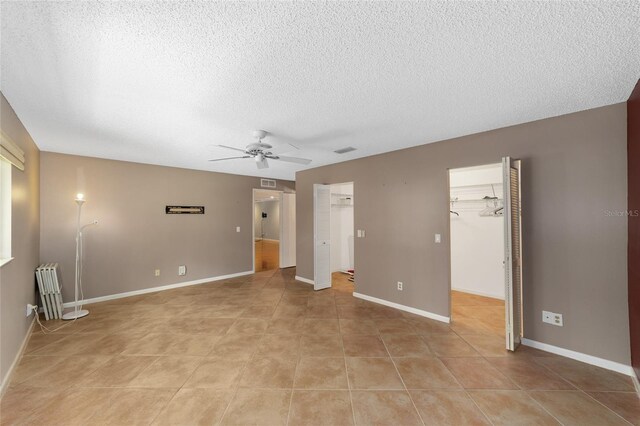 9085 SW 96th Ln Unit B, Ocala, FL 34481 - empty room with ceiling fan, a textured ceiling, light tile patterned floors, and radiator