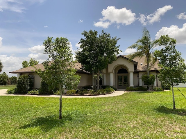 9923 SE 64th Ave, Belleview, FL 34420 - view of front facade featuring french doors, stucco siding, and a front lawn