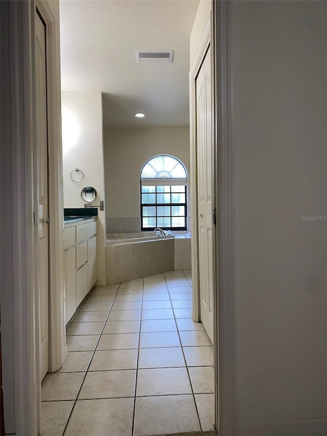 9923 SE 64th Ave, Belleview, FL 34420 - full bath with tile patterned flooring, tiled tub, vanity, a textured ceiling, and recessed lighting