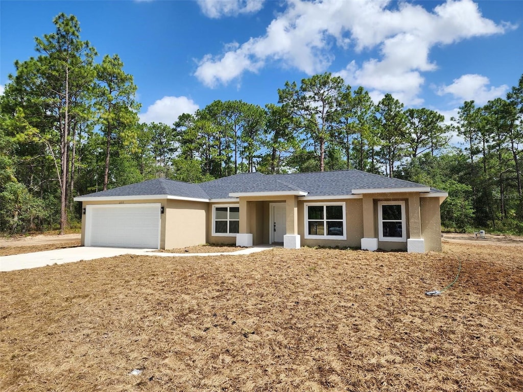 23213 NW Mallard Ave, Dunnellon, FL 34431 - ranch-style house with stucco siding, a garage, and driveway