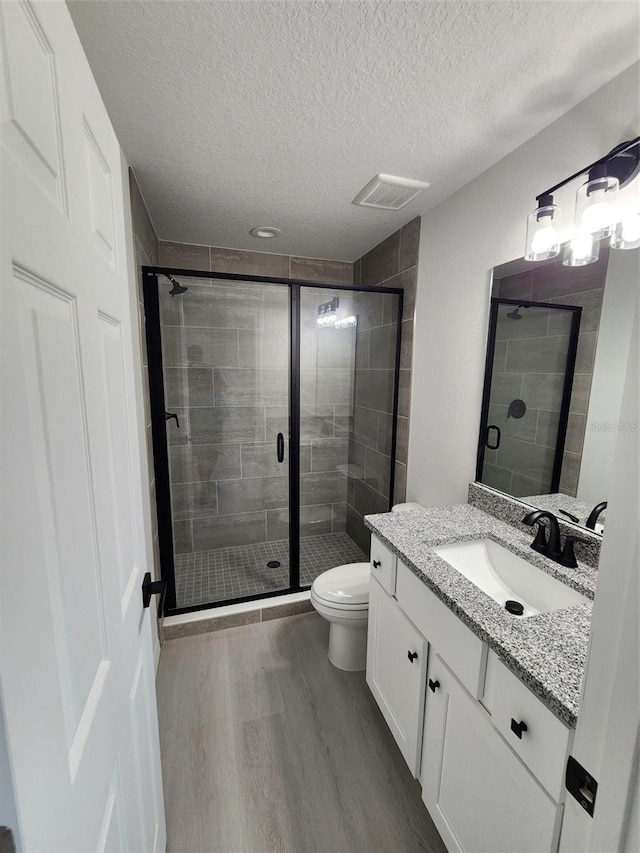 1780 Winding Hills Rd, Dunnellon, FL 34431 - bathroom featuring wood finished floors, vanity, a textured ceiling, and a stall shower