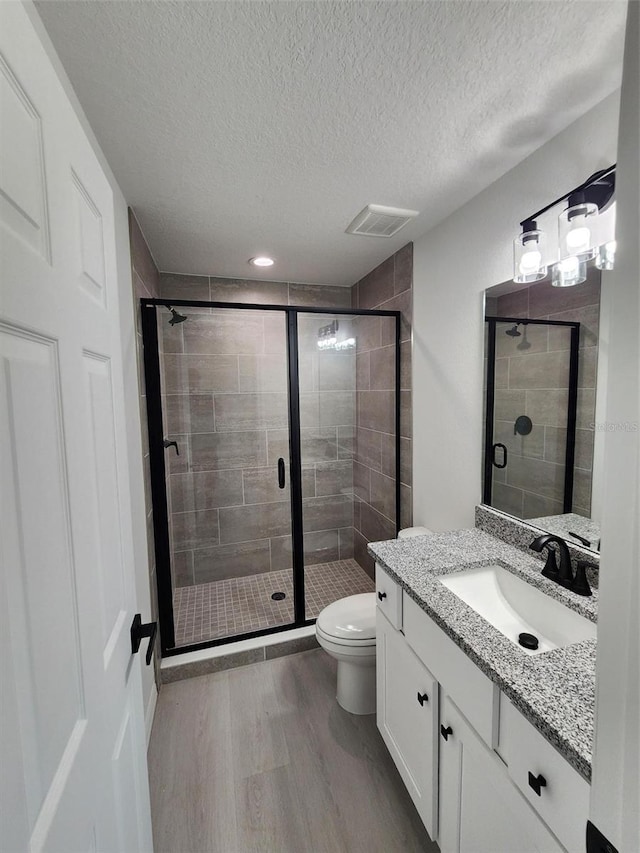 1780 Winding Hills Rd, Dunnellon, FL 34431 - bathroom with wood finished floors, vanity, a stall shower, and a textured ceiling