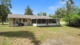 7808 E Savannah Dr, Floral City, FL 34436 - rear view of house featuring a sunroom and a yard