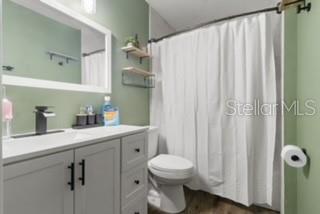 7808 E Savannah Dr, Floral City, FL 34436 - bathroom featuring vanity, curtained shower, and wood finished floors