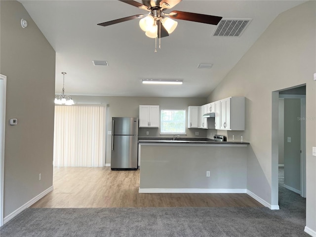 185 Malauka Loop, Ocklawaha, FL 32179 - kitchen featuring freestanding refrigerator, a peninsula, dark countertops, a ceiling fan, and light colored carpet