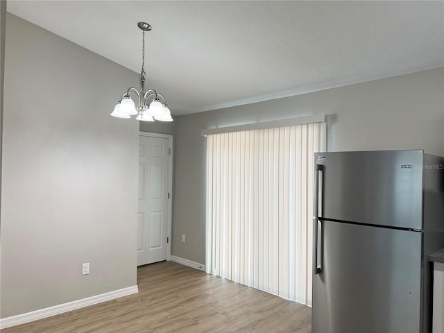 185 Malauka Loop, Ocklawaha, FL 32179 - unfurnished dining area featuring light wood-style floors and a chandelier