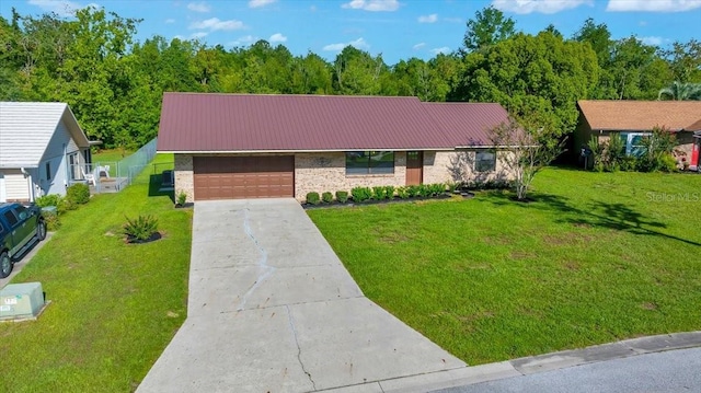 6142 SE 37th Ter, Ocala, FL 34480 - view of front of property featuring concrete driveway, an attached garage, a front yard, brick siding, and a metal roof
