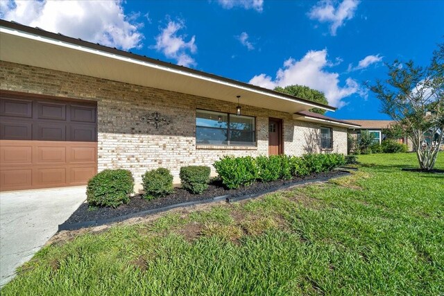6142 SE 37th Ter, Ocala, FL 34480 - view of property exterior featuring brick siding, a yard, and a garage