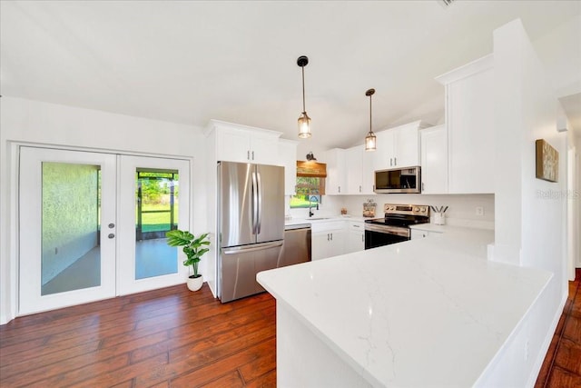 6142 SE 37th Ter, Ocala, FL 34480 - kitchen with stainless steel appliances, a peninsula, healthy amount of natural light, dark wood-style flooring, and vaulted ceiling