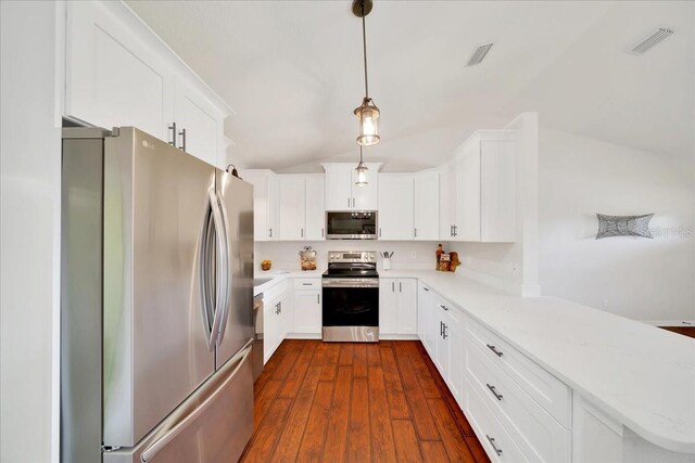 6142 SE 37th Ter, Ocala, FL 34480 - kitchen featuring stainless steel appliances, a peninsula, lofted ceiling, white cabinets, and dark wood-style floors