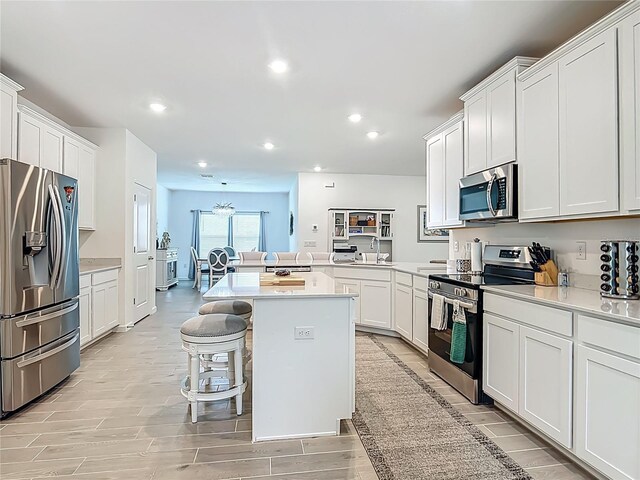 19424 SW 77th Loop, Dunnellon, FL 34432 - kitchen featuring stainless steel appliances, light countertops, a kitchen breakfast bar, white cabinetry, and recessed lighting