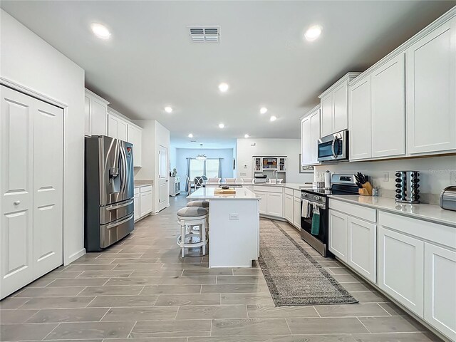 19424 SW 77th Loop, Dunnellon, FL 34432 - kitchen featuring stainless steel appliances, light countertops, white cabinetry, a breakfast bar area, and recessed lighting