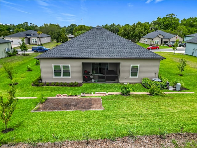 19424 SW 77th Loop, Dunnellon, FL 34432 - rear view of house with a shingled roof, a sunroom, a lawn, and a residential view