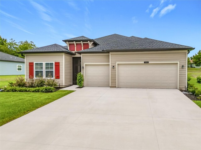 19424 SW 77th Loop, Dunnellon, FL 34432 - prairie-style house with an attached garage, a front yard, driveway, and a shingled roof