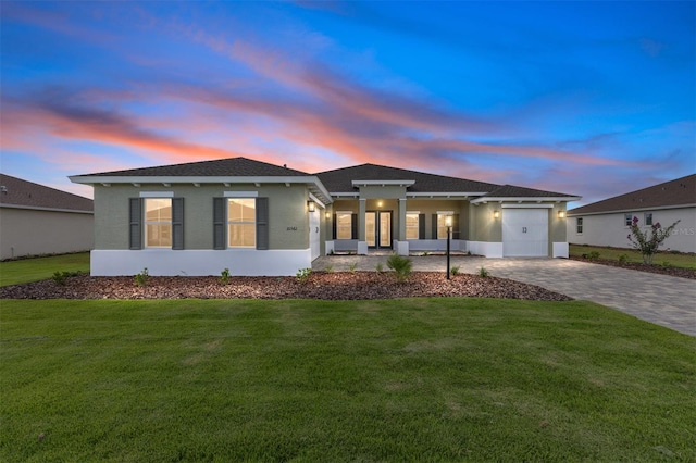 10561 SW 98th Pl, Ocala, FL 34481 - view of front facade featuring a garage, decorative driveway, stucco siding, and a front lawn