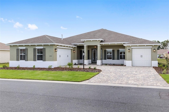 10561 SW 98th Pl, Ocala, FL 34481 - view of front of house with a garage, stucco siding, a front lawn, decorative driveway, and a shingled roof