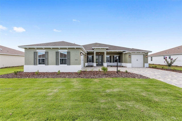 10561 SW 98th Pl, Ocala, FL 34481 - view of front of home featuring an attached garage, a front lawn, decorative driveway, and stucco siding
