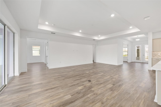 10561 SW 98th Pl, Ocala, FL 34481 - unfurnished living room with a raised ceiling, light wood-type flooring, recessed lighting, and plenty of natural light