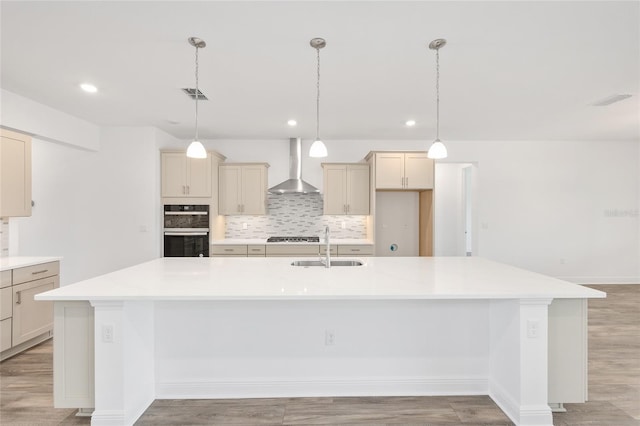 10561 SW 98th Pl, Ocala, FL 34481 - kitchen featuring wall chimney exhaust hood, tasteful backsplash, a spacious island, double oven, and light wood-style flooring