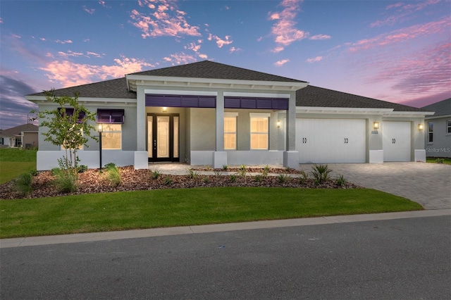10026 SW 85th Place Rd, Ocala, FL 34481 - view of front of house with an attached garage, stucco siding, a lawn, decorative driveway, and roof with shingles