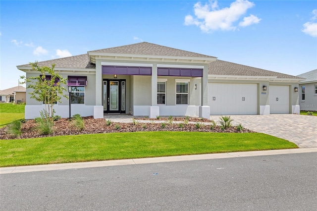 10026 SW 85th Place Rd, Ocala, FL 34481 - view of front of property featuring a front yard, a garage, stucco siding, decorative driveway, and a shingled roof