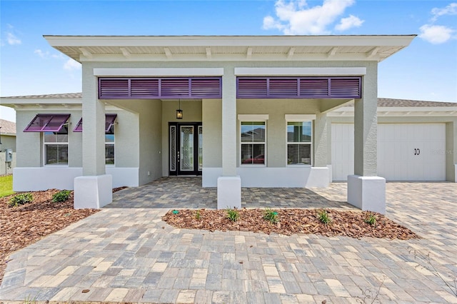 10026 SW 85th Place Rd, Ocala, FL 34481 - view of front of home featuring stucco siding, decorative driveway, and a garage