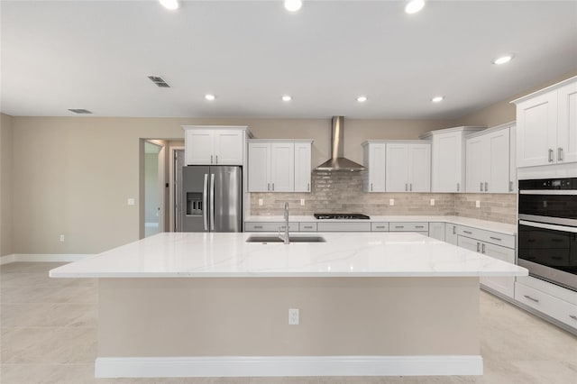 10026 SW 85th Place Rd, Ocala, FL 34481 - kitchen with appliances with stainless steel finishes, wall chimney exhaust hood, decorative backsplash, white cabinets, and a kitchen island with sink