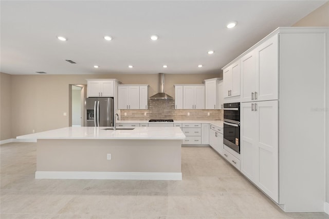 10026 SW 85th Place Rd, Ocala, FL 34481 - kitchen with stainless steel appliances, wall chimney exhaust hood, decorative backsplash, a kitchen island with sink, and white cabinetry