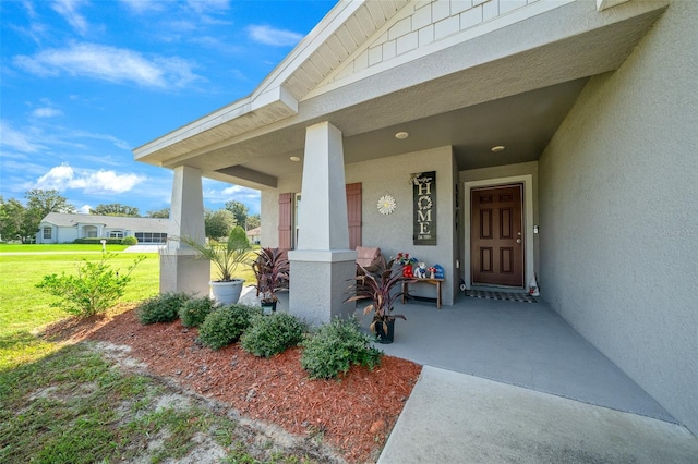 11330 SW 61st Cir, Ocala, FL 34476 - doorway to property featuring stucco siding, covered porch, and a yard