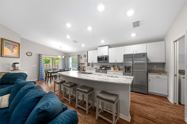 11330 SW 61st Cir, Ocala, FL 34476 - kitchen featuring stainless steel appliances, open floor plan, a kitchen breakfast bar, lofted ceiling, and white cabinets