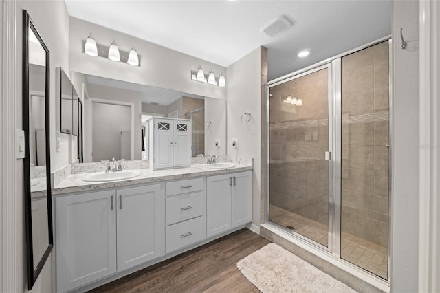 11330 SW 61st Cir, Ocala, FL 34476 - full bathroom featuring double vanity, a stall shower, and wood finished floors