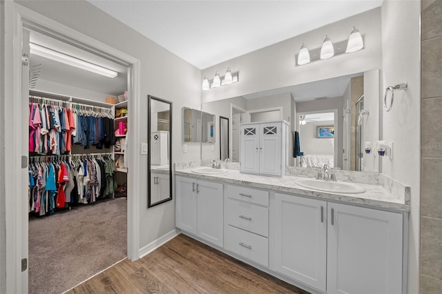 11330 SW 61st Cir, Ocala, FL 34476 - bathroom featuring double vanity, wood finished floors, a ceiling fan, and a spacious closet