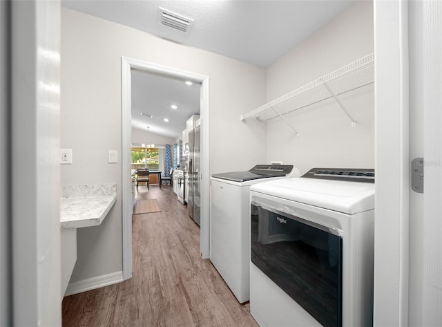 11330 SW 61st Cir, Ocala, FL 34476 - laundry room with washing machine and dryer and light wood-type flooring