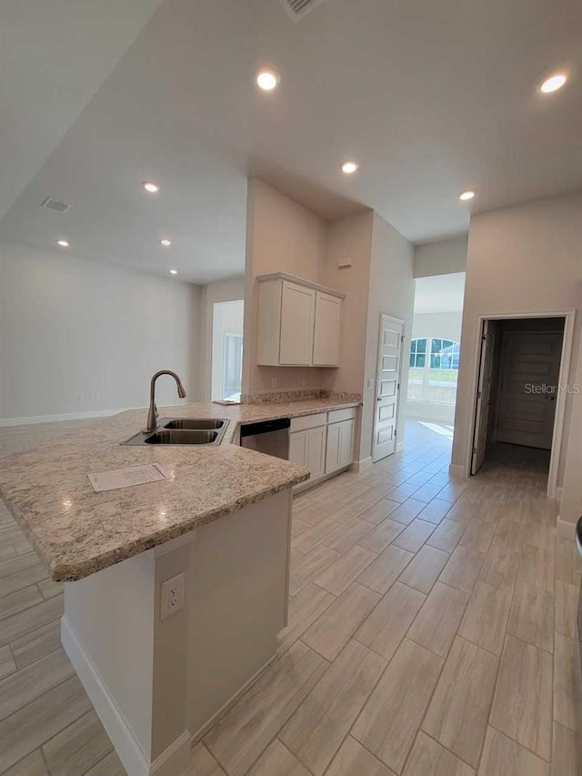 12384 SW 96th Ln, Dunnellon, FL 34432 - kitchen with light stone counters, stainless steel dishwasher, wood tiled floors, white cabinets, and recessed lighting