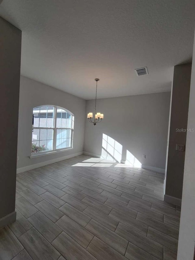 12384 SW 96th Ln, Dunnellon, FL 34432 - unfurnished room with wood finish floors, a chandelier, and a textured ceiling
