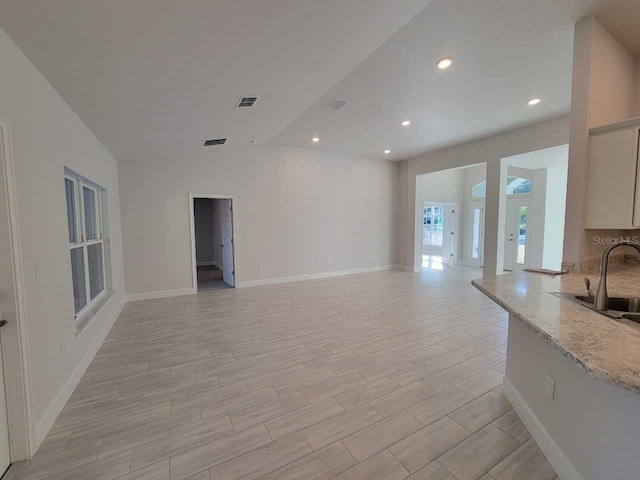 12384 SW 96th Ln, Dunnellon, FL 34432 - unfurnished living room with recessed lighting, light wood-style floors, and lofted ceiling