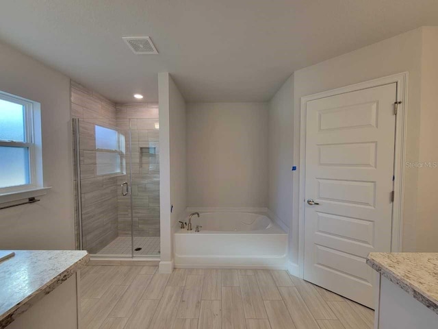 12384 SW 96th Ln, Dunnellon, FL 34432 - full bath featuring a garden tub, vanity, a shower stall, wood tiled floors, and recessed lighting