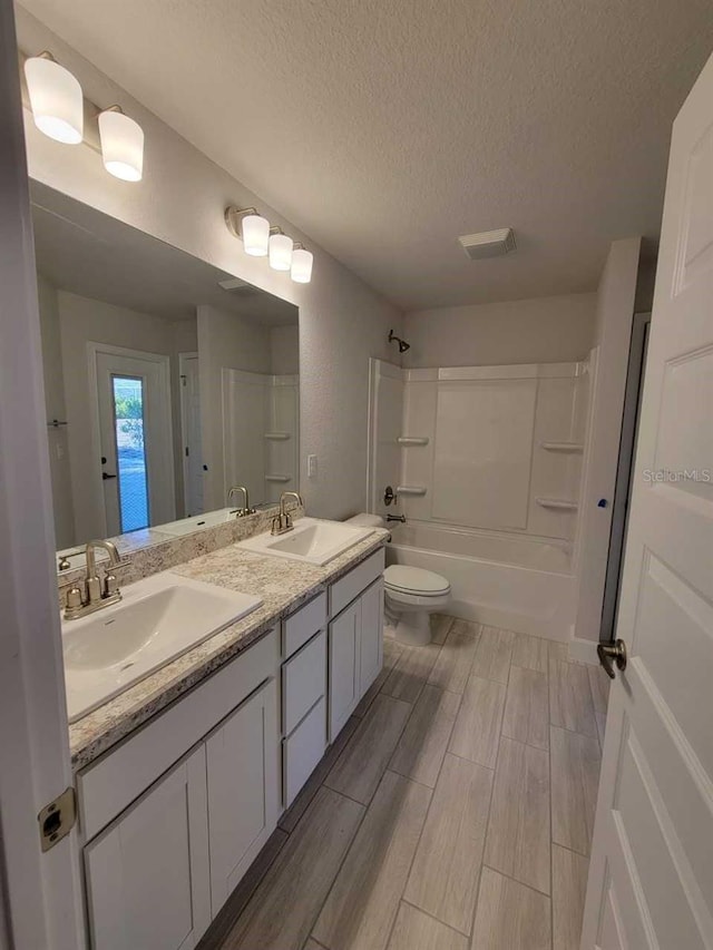 12384 SW 96th Ln, Dunnellon, FL 34432 - bathroom featuring a textured ceiling, double vanity, shower / bath combination, and wood finished floors