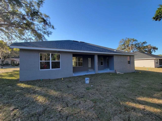 12384 SW 96th Ln, Dunnellon, FL 34432 - rear view of property featuring stucco siding, a yard, a patio, and a shingled roof