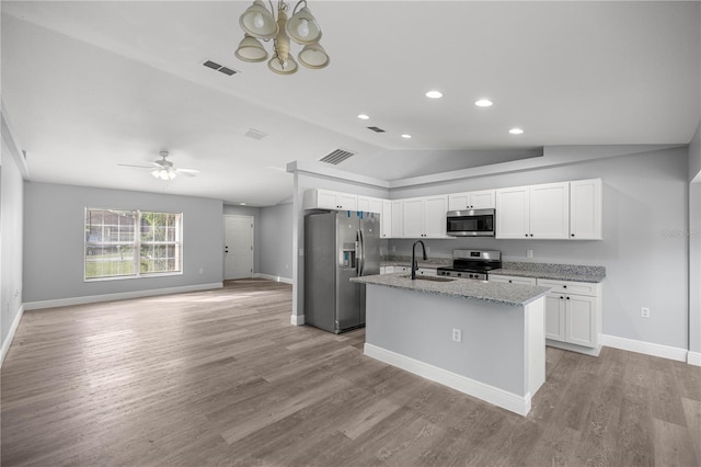 51 Pine Trace Loop, Ocala, FL 34472 - kitchen featuring stainless steel appliances, vaulted ceiling, white cabinetry, light wood finished floors, and light stone countertops