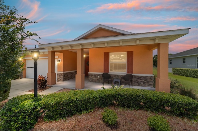 9236 SW 91st Court Rd, Ocala, FL 34481 - view of front facade with stone siding, covered porch, stucco siding, and concrete driveway