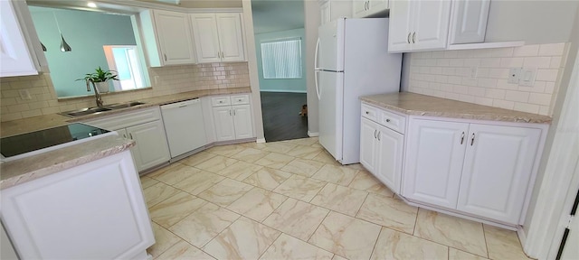 8771 SW 115th St, Ocala, FL 34481 - kitchen with white appliances, backsplash, white cabinetry, and light marble finish flooring