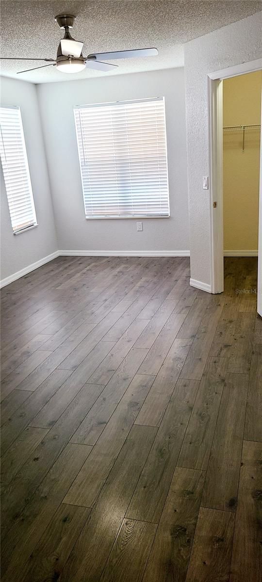 8771 SW 115th St, Ocala, FL 34481 - empty room featuring dark wood-type flooring, a ceiling fan, and a textured ceiling