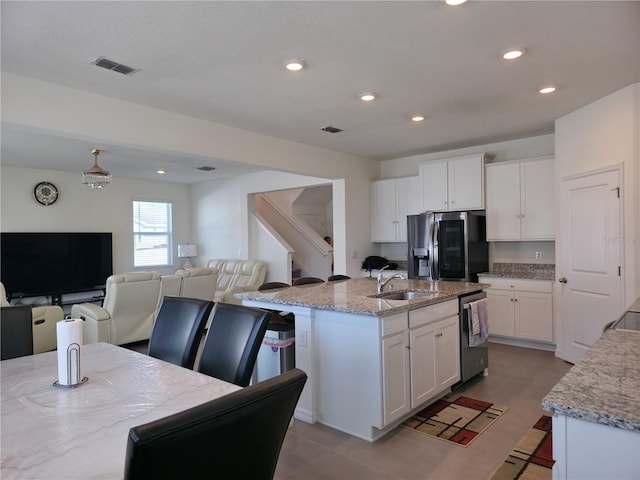 5962 SW 80th Ln, Ocala, FL 34476 - kitchen featuring appliances with stainless steel finishes, white cabinetry, light stone counters, recessed lighting, and an island with sink