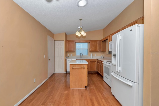 9069 SW 91st Cir, Ocala, FL 34481 - kitchen with white appliances, light countertops, a kitchen island, light wood finished floors, and a textured ceiling