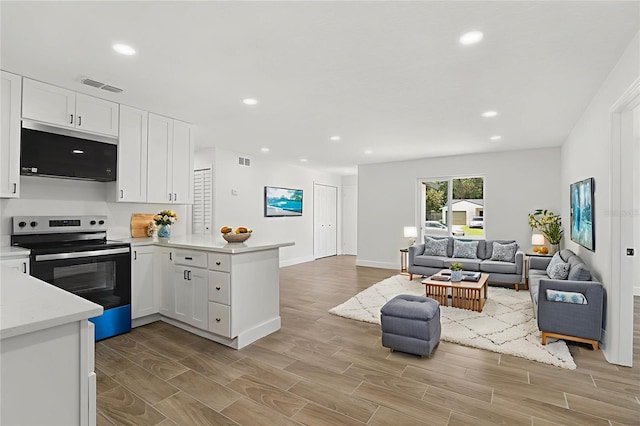 2817 Rheims Ave, Melbourne, FL 32935 - kitchen with stainless steel appliances, a peninsula, open floor plan, white cabinetry, and recessed lighting